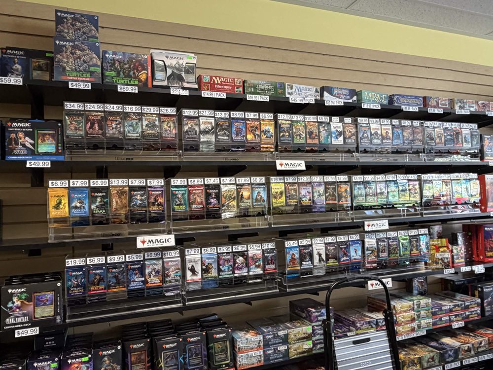 A wall of sealed trading card game booster boxes and packs at Cardtropolis TCG